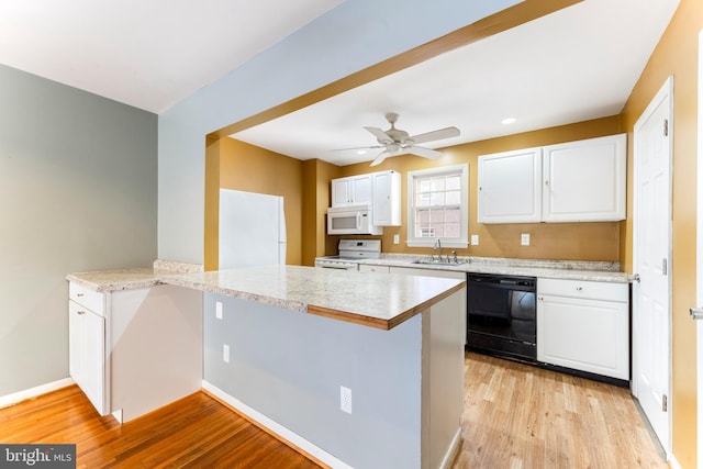 kitchen featuring sink, white cabinets, light stone countertops, white appliances, and light hardwood / wood-style flooring