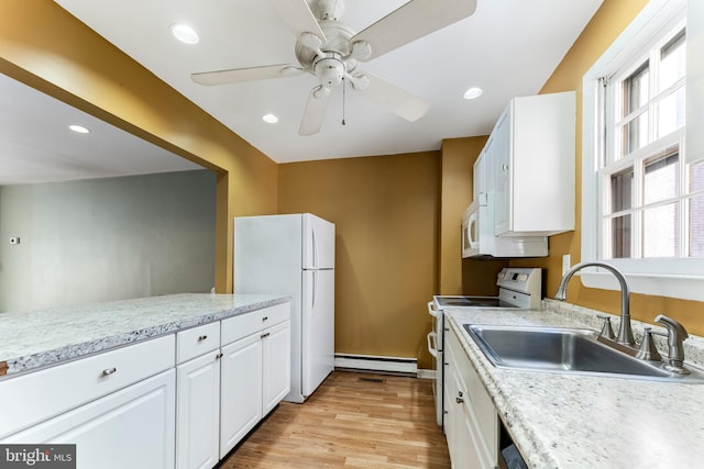 kitchen featuring sink, white cabinets, a baseboard heating unit, white appliances, and light hardwood / wood-style flooring