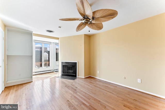 unfurnished living room with baseboard heating, ceiling fan, and light hardwood / wood-style flooring