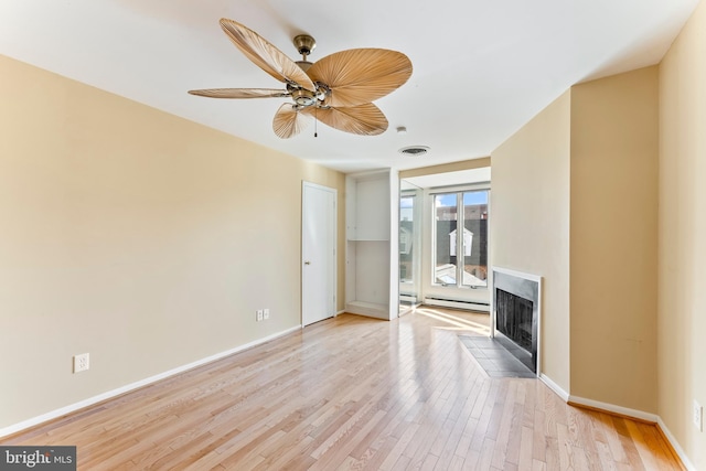 unfurnished living room featuring ceiling fan, light hardwood / wood-style floors, and baseboard heating