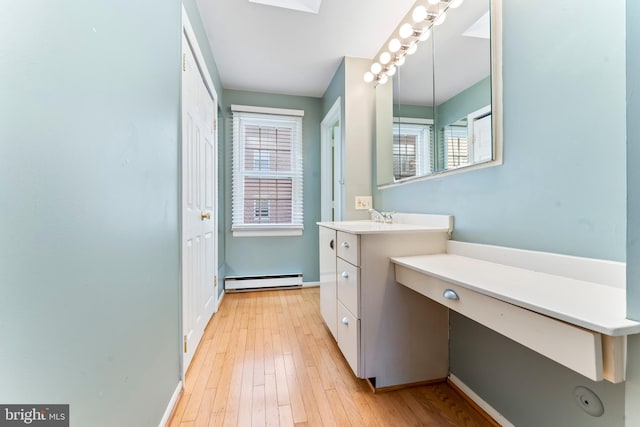 bathroom with vanity, wood-type flooring, and baseboard heating