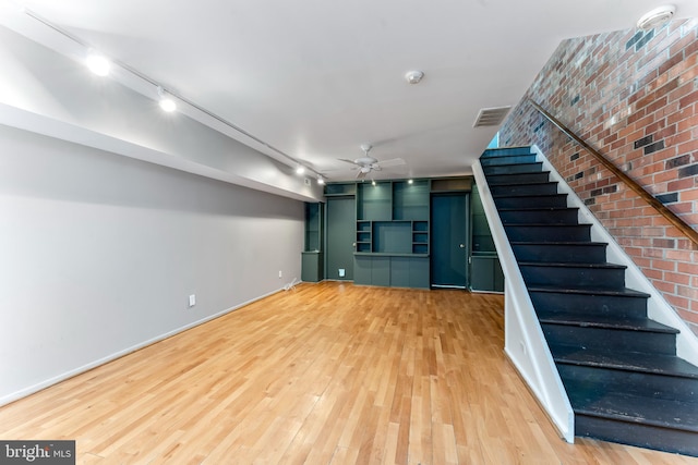 unfurnished living room featuring hardwood / wood-style floors, rail lighting, and ceiling fan