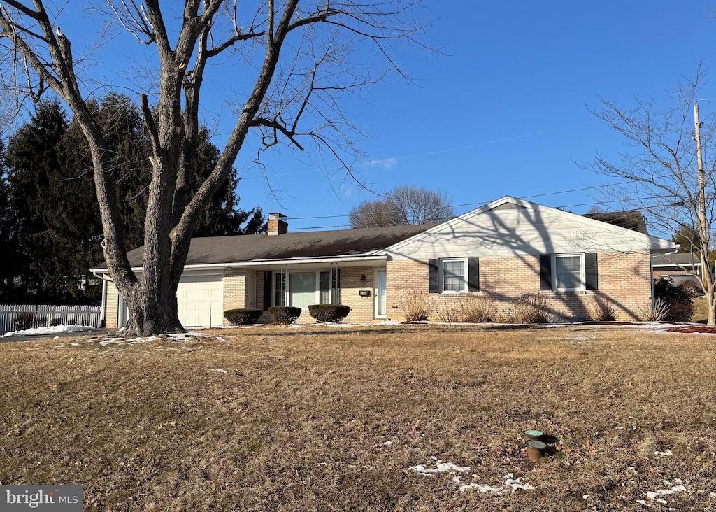 ranch-style house with a garage and a front lawn