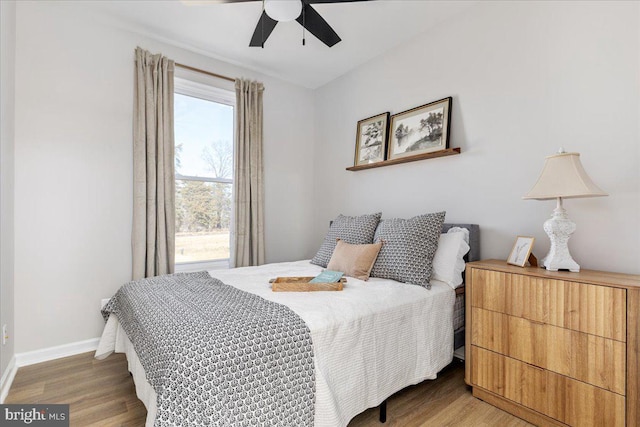 bedroom featuring multiple windows, hardwood / wood-style flooring, and ceiling fan