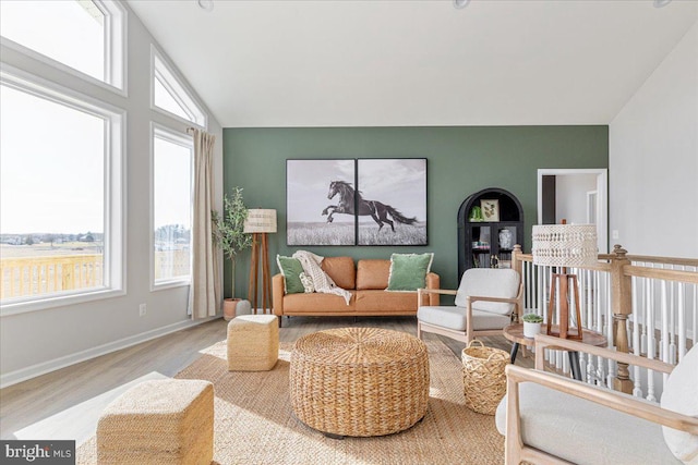 living area featuring vaulted ceiling and light hardwood / wood-style floors