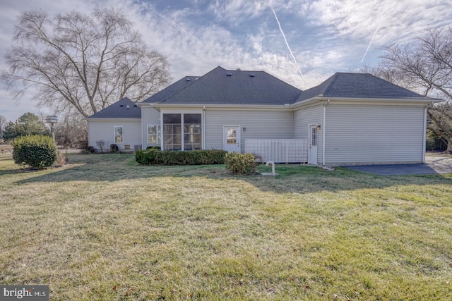 back of property featuring a yard and a sunroom