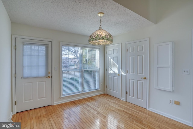 entrance foyer with light hardwood / wood-style flooring and a textured ceiling