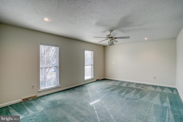 empty room with ceiling fan, a textured ceiling, and carpet flooring