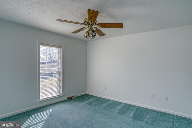 carpeted empty room with ceiling fan and a textured ceiling