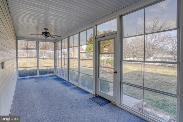 unfurnished sunroom with ceiling fan