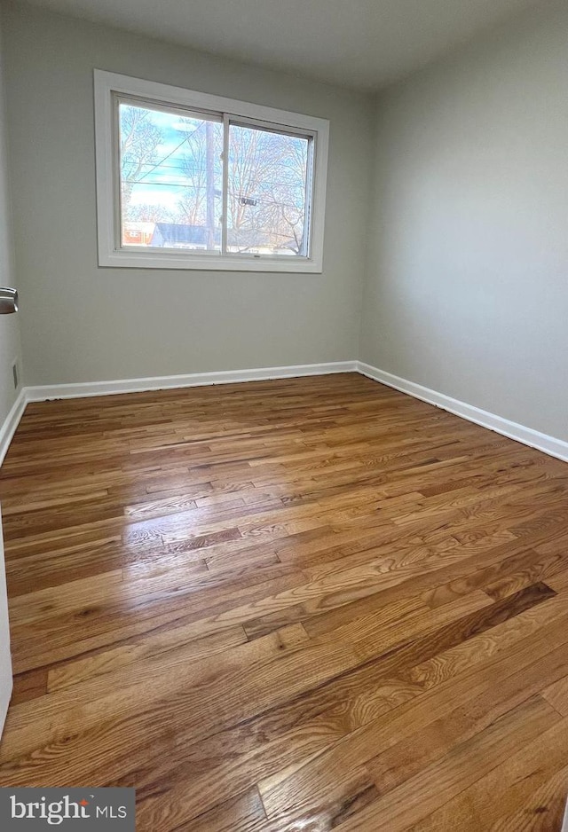 empty room with wood-type flooring and a wealth of natural light