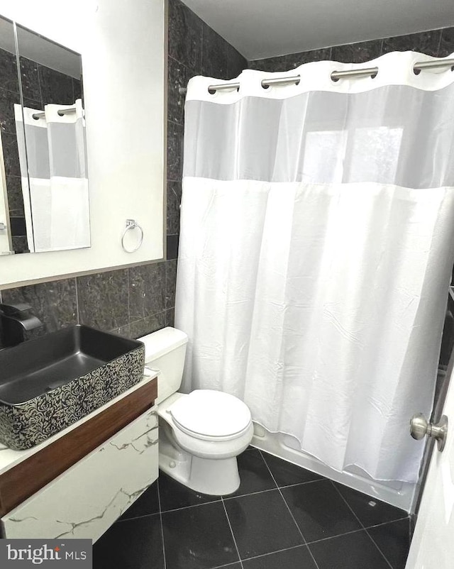 bathroom featuring tile walls, vanity, a shower with curtain, tile patterned floors, and toilet