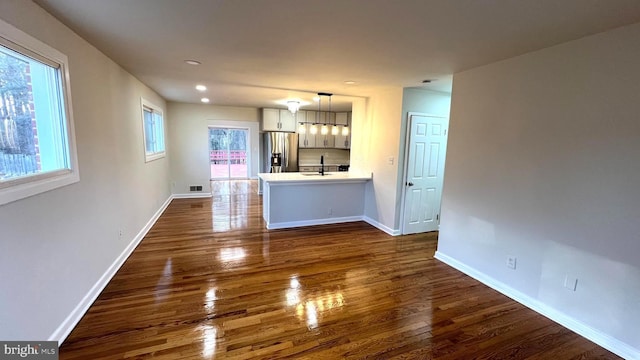 unfurnished living room featuring dark hardwood / wood-style flooring and sink