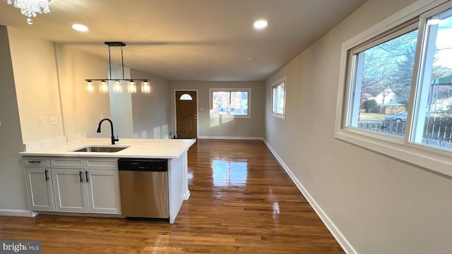 kitchen with sink, white cabinetry, decorative light fixtures, dark hardwood / wood-style flooring, and dishwasher