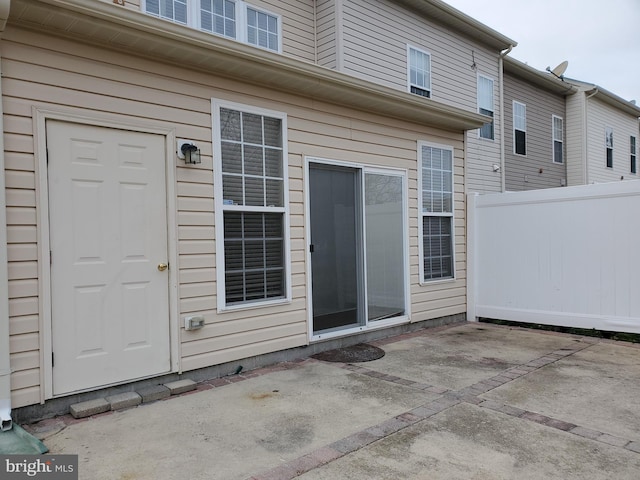 rear view of house featuring a patio and fence