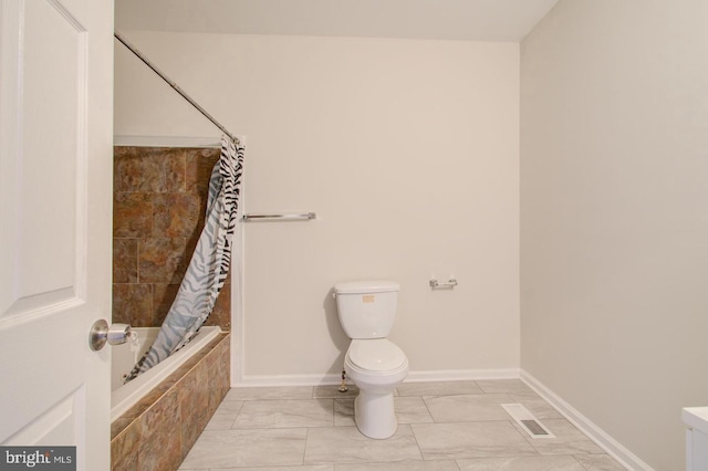 bathroom featuring toilet and shower / bath combo with shower curtain