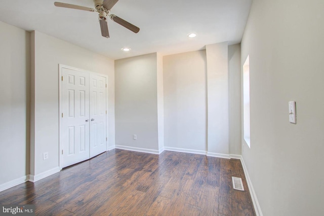 unfurnished bedroom featuring ceiling fan and dark hardwood / wood-style flooring