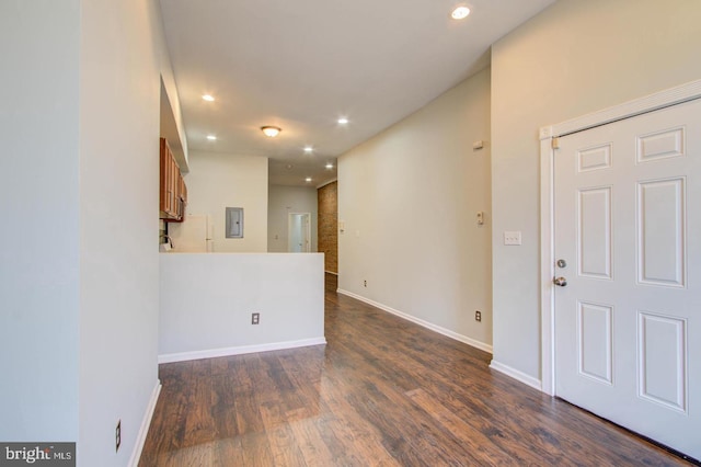 empty room with dark hardwood / wood-style flooring and electric panel