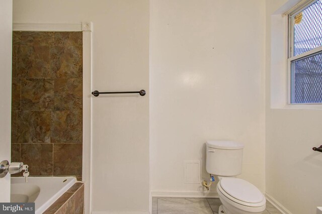 bathroom with tiled bath and toilet