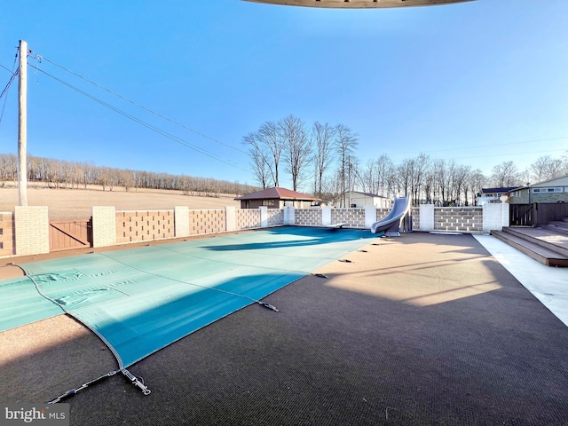 view of swimming pool with a water slide