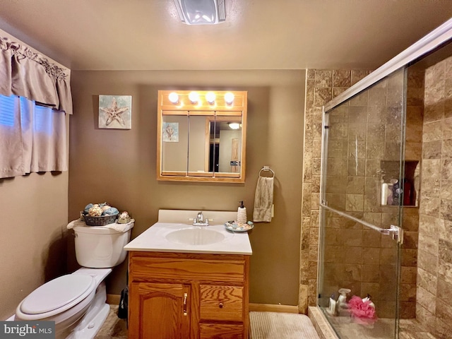 bathroom with walk in shower, vanity, and toilet