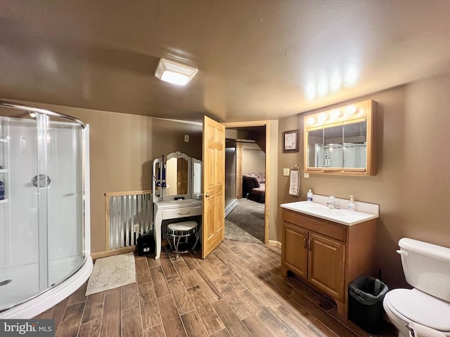 bathroom featuring vanity, toilet, and an enclosed shower