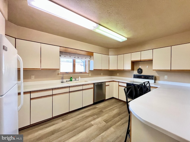 kitchen featuring dishwasher, sink, white cabinets, white refrigerator, and light wood-type flooring