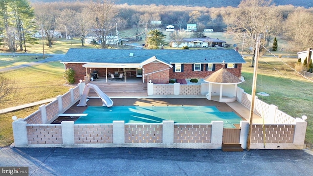 back of house featuring a yard and a swimming pool side deck