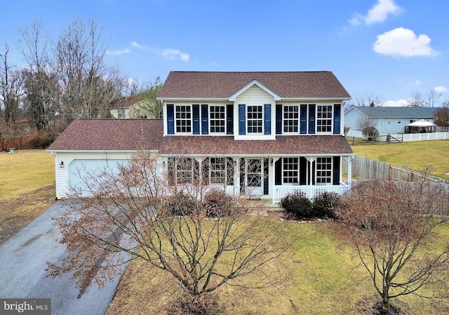 colonial-style house featuring a front lawn and a garage