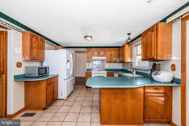 kitchen with white appliances, decorative backsplash, light tile patterned flooring, sink, and kitchen peninsula