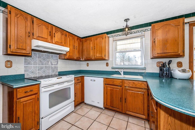 kitchen with white appliances, sink, backsplash, and a textured ceiling