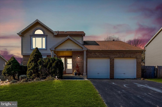 front facade featuring a garage and a lawn