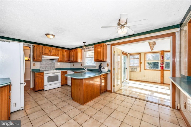 kitchen featuring white appliances, sink, a textured ceiling, and kitchen peninsula