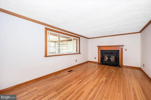 unfurnished living room featuring light wood-type flooring, ornamental molding, and a textured ceiling