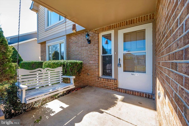 view of exterior entry with a patio