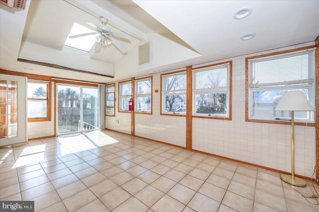 interior space featuring ceiling fan and lofted ceiling with skylight