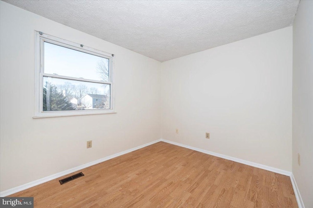 spare room with light hardwood / wood-style flooring and a textured ceiling