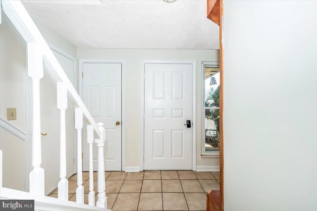 entrance foyer featuring light tile patterned flooring and a textured ceiling