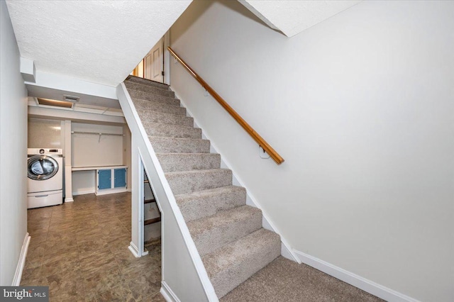 staircase with washer / clothes dryer and a textured ceiling