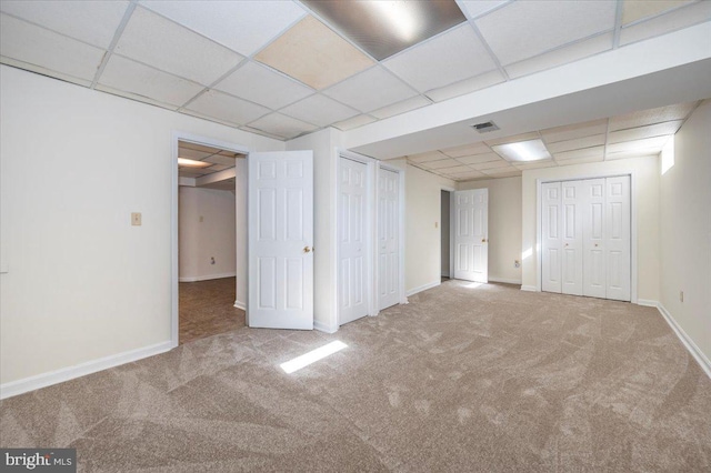 basement featuring carpet and a drop ceiling