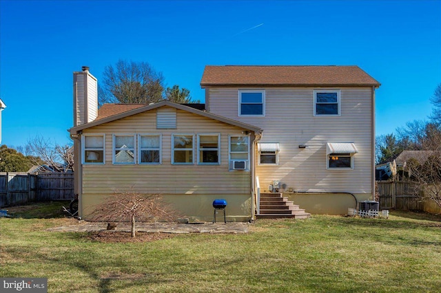 rear view of property with central AC unit, a yard, and cooling unit