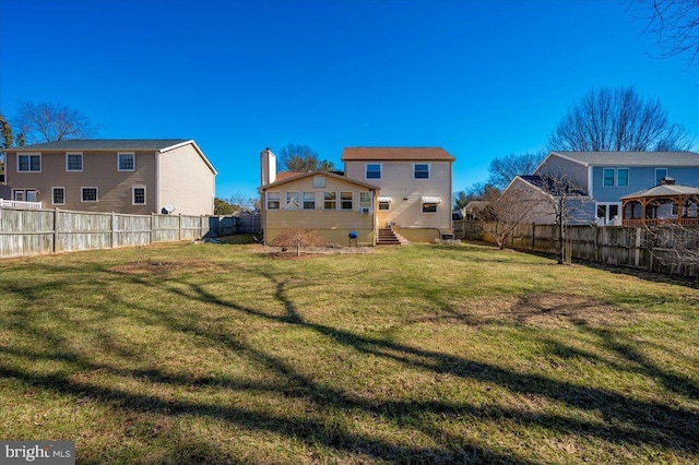 rear view of property featuring a lawn