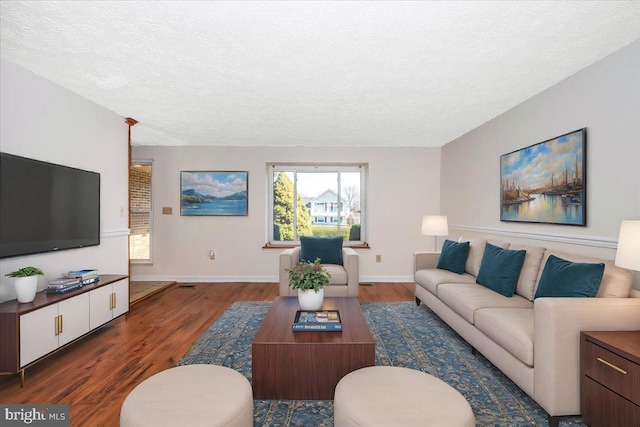 living room with dark hardwood / wood-style flooring and a textured ceiling