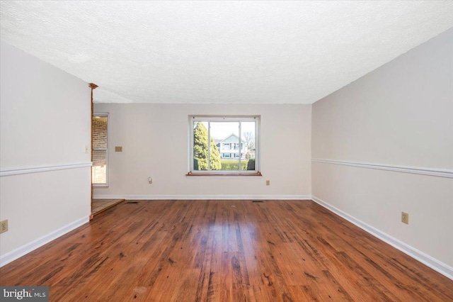 spare room featuring a textured ceiling and hardwood / wood-style floors