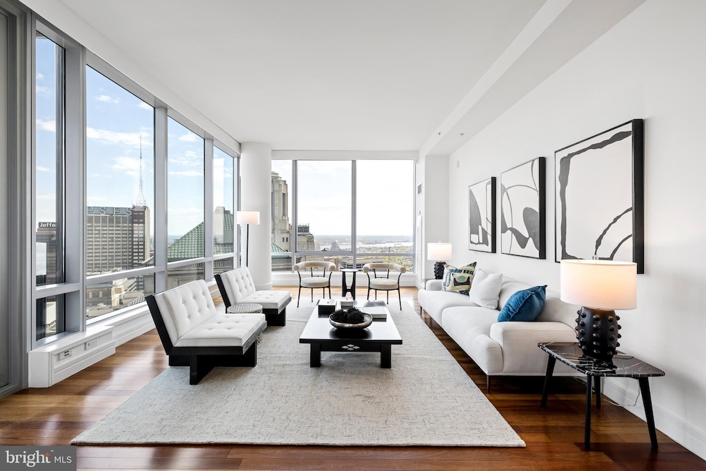 living room with dark wood-type flooring and floor to ceiling windows