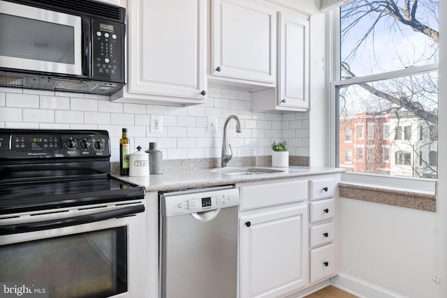 kitchen featuring white cabinetry, sink, decorative backsplash, and stainless steel appliances