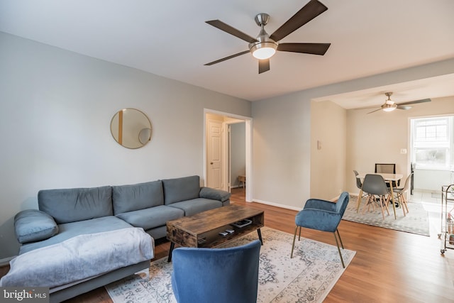 living room with wood-type flooring and ceiling fan