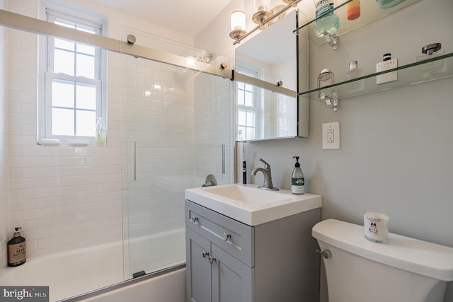 full bathroom featuring enclosed tub / shower combo, vanity, and toilet