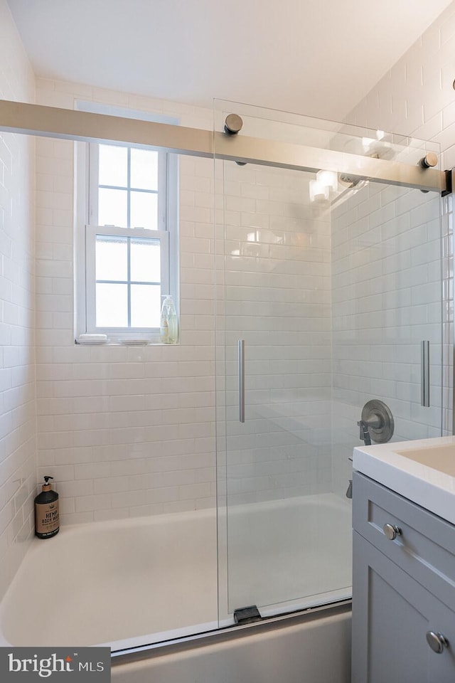 bathroom featuring bath / shower combo with glass door and vanity