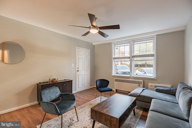 living room with ceiling fan, radiator heating unit, and light wood-type flooring